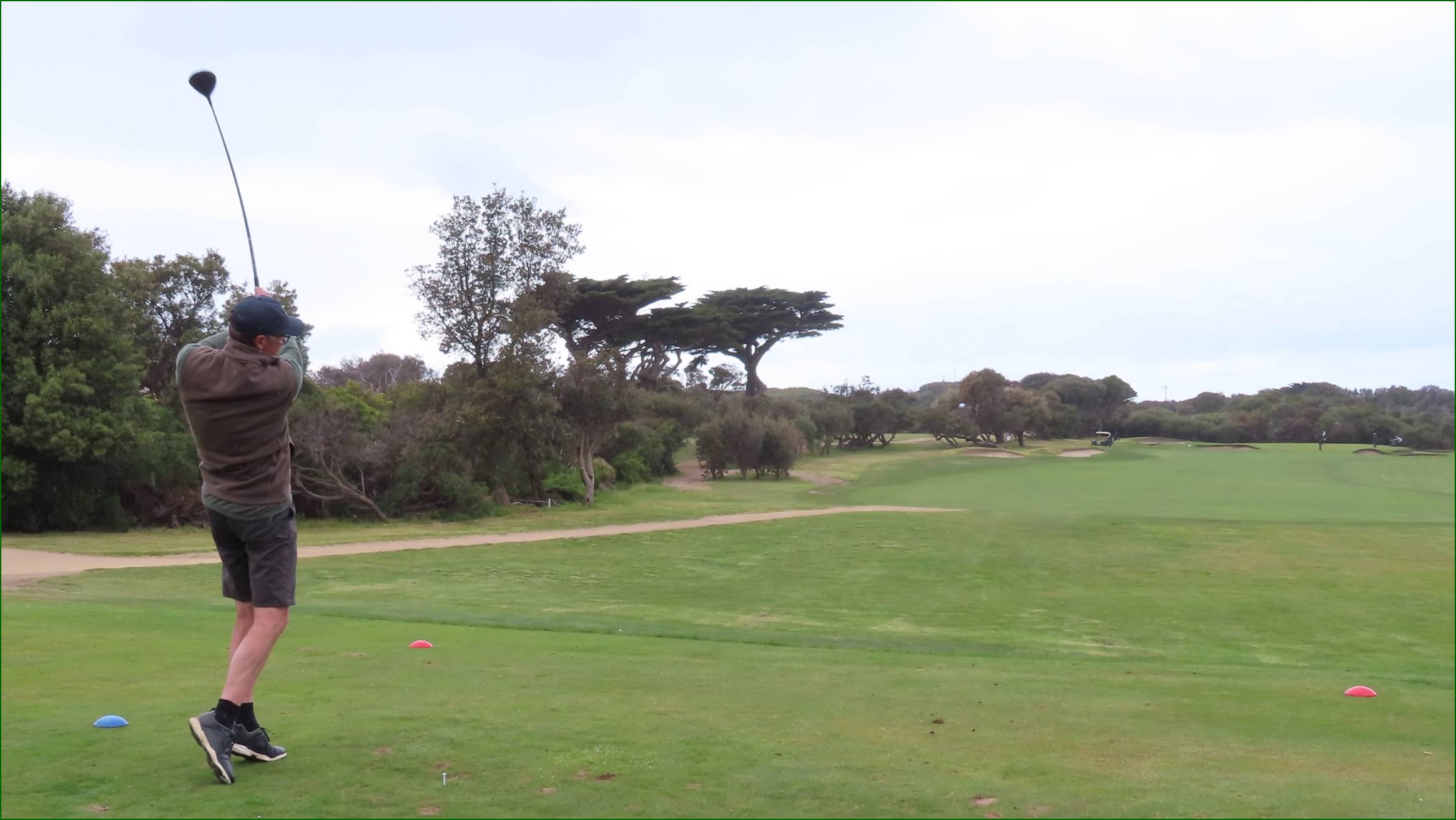 A golf course with trees and a path

Description automatically generated