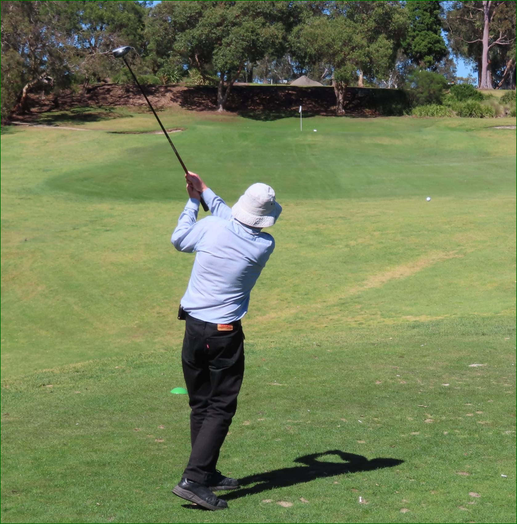 A person swinging a golf club

Description automatically generated